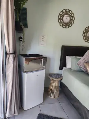 a room with a bed and a small table and a table at Be Our Guest Near OR Tambo International Airport 2 in Boksburg