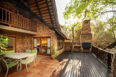 a deck with a table and a television on a house at Kruger Park Lodge Unit 526 in Hazyview