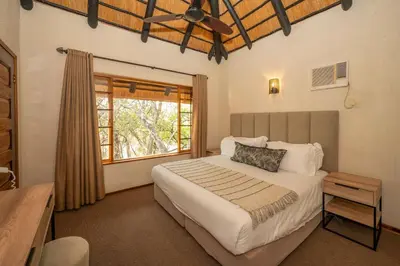 a bedroom with a large bed and a window at Kruger Park Lodge Unit 526 in Hazyview