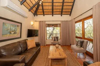 a living room with a leather couch and a table at Kruger Park Lodge Unit 526 in Hazyview
