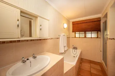 a bathroom with a sink and a tub and a mirror at Kruger Park Lodge Unit 526 in Hazyview