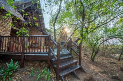 a set of stairs leading up to a house with the sun shining at Kruger Park Lodge Unit 526 in Hazyview