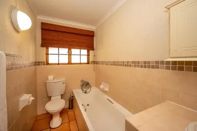 a bathroom with a toilet and a bath tub at Kruger Park Lodge Unit 526 in Hazyview