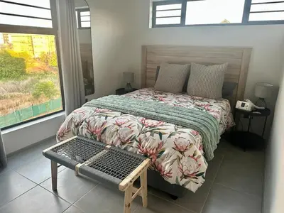 a bedroom with a bed and a window and a table at Business trip or Fun with the Family - you decide! in Pretoria