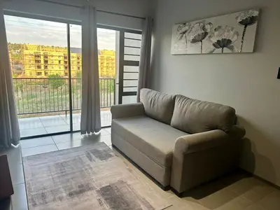 a living room with a couch and a large window at Business trip or Fun with the Family - you decide! in Pretoria
