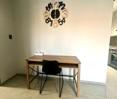 a table with a chair and a clock on the wall at Business trip or Fun with the Family - you decide! in Pretoria