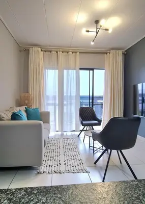 a living room with a couch and chairs and windows at Convenient Corner of GreenValley estate in Nelspruit