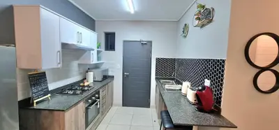 a kitchen with white cabinets and a counter top at Convenient Corner of GreenValley estate in Nelspruit