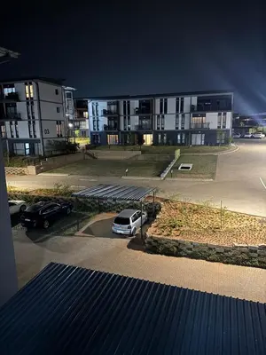 a parking lot with cars parked in front of a building at Convenient Corner of GreenValley estate in Nelspruit