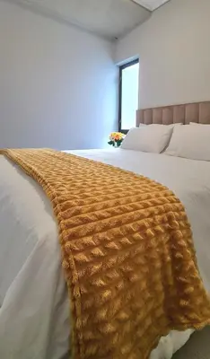 a brown blanket on a bed in a bedroom at Convenient Corner of GreenValley estate in Nelspruit
