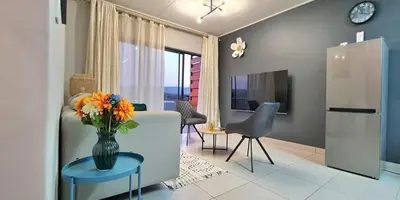 a living room with a vase of flowers on a table at Convenient Corner of GreenValley estate in Nelspruit