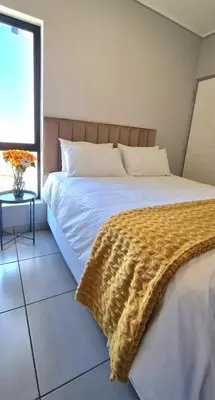 a bedroom with a bed with a blanket on it at Convenient Corner of GreenValley estate in Nelspruit