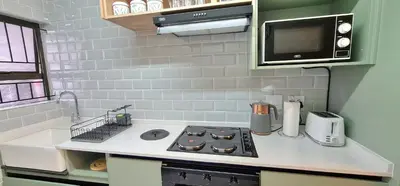 a small kitchen with a stove and a microwave at Closer to CBD by UrbanCove in Nelspruit