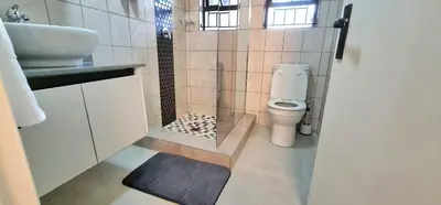 a bathroom with a toilet and a sink at Closer to CBD by UrbanCove in Nelspruit