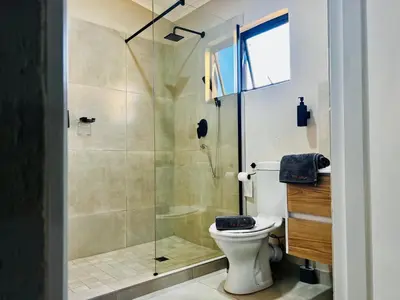 a bathroom with a toilet and a glass shower at TLS Cottages in Buffelspruit