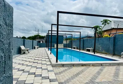 a swimming pool with a bench next to a fence at TLS Cottages in Buffelspruit