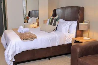 a bedroom with a large bed with towels on it at Brown, Warm and Cozy, Menlyn Maine Residences 926 in Pretoria