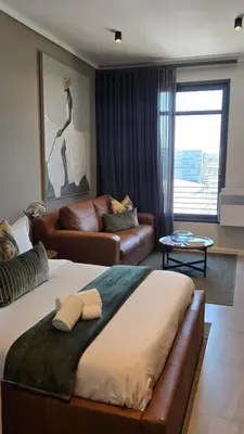 a living room with a bed and a couch at Green Serene Studio, Menlyn Maine Residences 826 in Pretoria