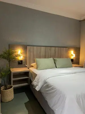 a bedroom with a large white bed and two lamps at Fourteen38 Mews Guesthouse in Dwarsloop