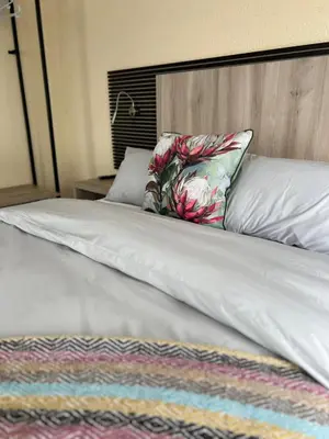 a white bed with a pillow on top of it at Fourteen38 Mews Guesthouse in Dwarsloop