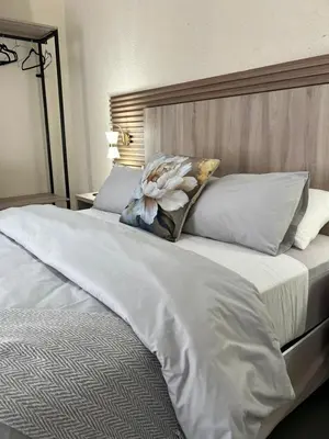 a large white bed with a flower pillow on it at Fourteen38 Mews Guesthouse in Dwarsloop