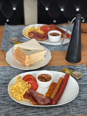 a table with two plates of breakfast food on it at Fourteen38 Mews Guesthouse in Dwarsloop