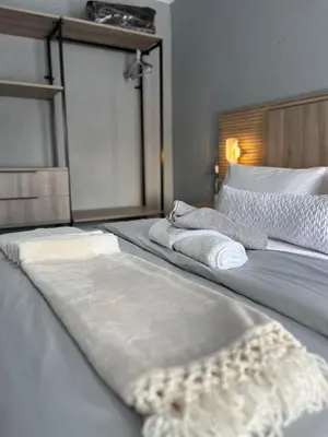 a large bed with white sheets and pillows on it at Fourteen38 Mews Guesthouse in Dwarsloop