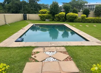 a swimming pool in the middle of a yard at Stylish Riverside Home with Pool, Braai & Wi-Fi in Nelspruit