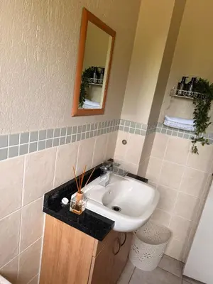 a bathroom with a sink and a mirror at Stylish Riverside Home with Pool, Braai & Wi-Fi in Nelspruit
