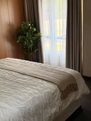 a bedroom with a bed with a window and a plant at Stylish Riverside Home with Pool, Braai & Wi-Fi in Nelspruit
