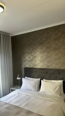a bedroom with a large bed with white pillows at The Sweet Serenity Suite in Midrand