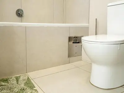 a white bathroom with a toilet and a tub at The Sweet Serenity Suite in Midrand
