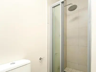 a bathroom with a shower and a toilet at The Sweet Serenity Suite in Midrand