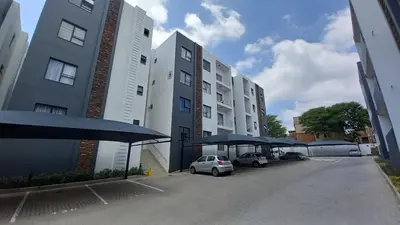 a parking lot with cars parked next to tall buildings at The Sweet Serenity Suite in Midrand