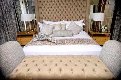 a bedroom with a large bed with two chairs at Beyond Borders Guest House in Polokwane