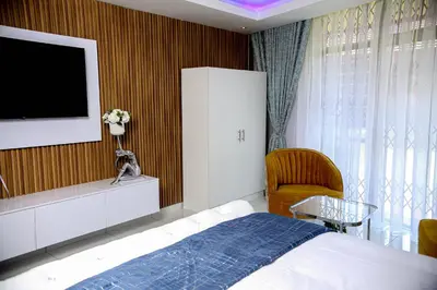 a bedroom with a bed and a tv on a wall at Beyond Borders Guest House in Polokwane