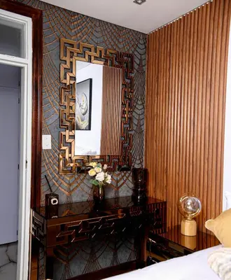 a bedroom with a mirror and a table with flowers at Beyond Borders Guest House in Polokwane