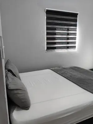a white bed in a room with a window at Calm Corner in Pretoria