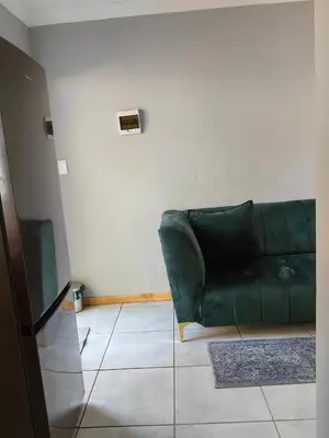 a green couch sitting in a living room at Calm Corner in Pretoria