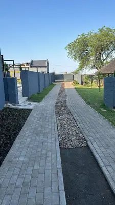 a brick walkway in a yard with a house at TLS Cottages