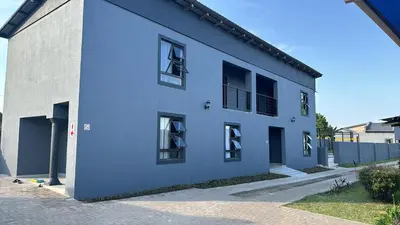 a blue building with windows on a street at TLS Cottages