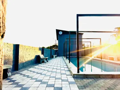 a swimming pool with a bench and a building at TLS Cottages