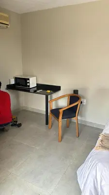 a room with a desk with a chair and a microwave at TLS Cottages