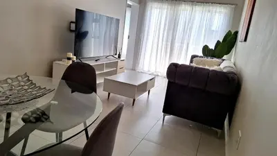 a living room with a table and a couch and a television at The Perfect Luxury Space at 93 on new in Midrand