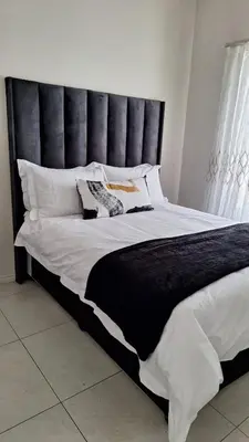 a large bed with a black headboard in a bedroom at The Perfect Luxury Space at 93 on new in Midrand