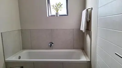 a white bath tub in a bathroom with a window at The Perfect Luxury Space at 93 on new in Midrand