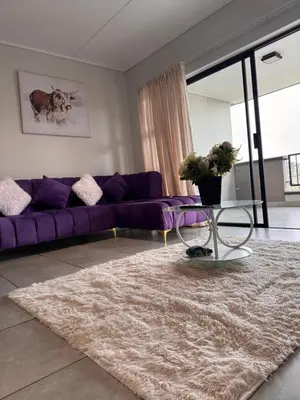a living room with a purple couch and a rug at Staycation At Munyaka Estate in Midrand