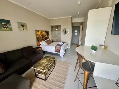 a living room with a couch and a bed at Menlyn Maine Residences 811 in Pretoria