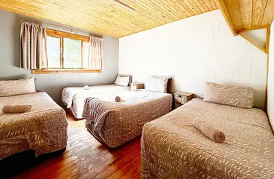 a room with three beds and a window at Elephant 1 Chalet Hippo Waterfront Lodge in Nelspruit