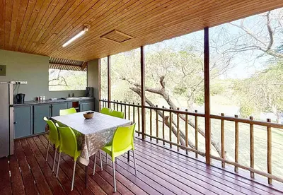 a kitchen with a table and chairs on a balcony at Elephant 1 Chalet Hippo Waterfront Lodge in Nelspruit